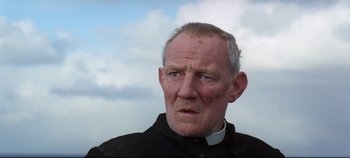 Movie still from “Ryan's Daughter” (1970), directed by David Lean – An older man wearing a priest's collar; Close Up shot, Low angle