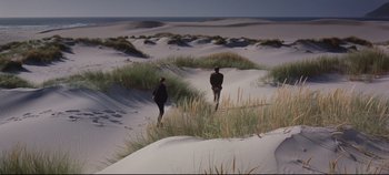 Movie still from “Ryan's Daughter” (1970), directed by David Lean – Two people are walking through the sand dunes; Extreme Wide shot, High angle