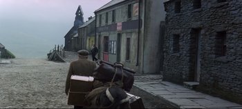 Movie still from “Ryan's Daughter” (1970), directed by David Lean – A man riding on the back of a horse down a street; Wide shot, High angle