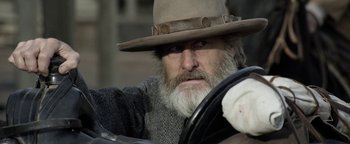Movie still from “Godless” (2017), directed by Scott Frank – An old man with a beard wearing a hat; Close Up shot, Over the shoulder angle