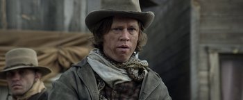 Movie still from “Godless” (2017), directed by Scott Frank – A man wearing a cowboy hat and a scarf; Close Up shot, Low angle
