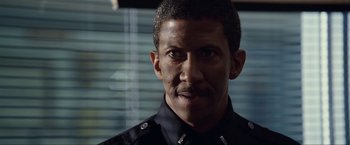 Movie still from “S.W.A.T.” (2003), directed by Clark Johnson – A man in a police uniform is looking at the camera; Close Up shot, Low angle