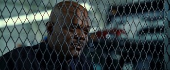 Movie still from “S.W.A.T.” (2003), directed by Clark Johnson – A person behind a chain link fence; Close Up shot, Low angle