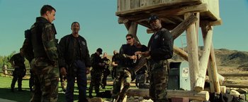 Movie still from “S.W.A.T.” (2003), directed by Clark Johnson – A group of men standing next to each other on a field; Medium shot, Low angle