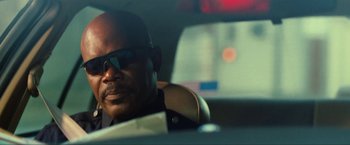 Movie still from “S.W.A.T.” (2003), directed by Clark Johnson – A person in a car wearing sunglasses; Close Up shot, Low angle