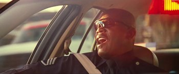 Movie still from “S.W.A.T.” (2003), directed by Clark Johnson – A person in a car wearing sunglasses; Close Up shot, Low angle