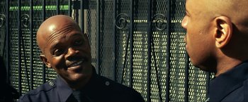 Movie still from “S.W.A.T.” (2003), directed by Clark Johnson – A man standing in front of a metal fence; Close Up shot, Low angle