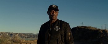 Movie still from “S.W.A.T.” (2003), directed by Clark Johnson – A man in a black jacket and a cap; Close Up shot, Low angle