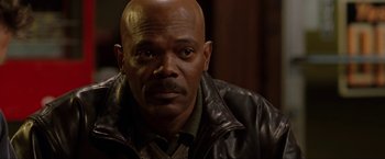 Movie still from “S.W.A.T.” (2003), directed by Clark Johnson – A man with a bald head wearing a brown leather jacket; Close Up shot, Over the shoulder angle