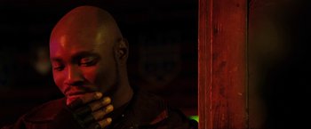 Movie still from “S.W.A.T.” (2003), directed by Clark Johnson – A man with his hand to his face in a dark room; Close Up shot, Low angle