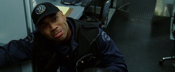 Movie still from “S.W.A.T.” (2003), directed by Clark Johnson – A man in a police uniform sitting in front of a computer; Close Up shot, Over the shoulder angle