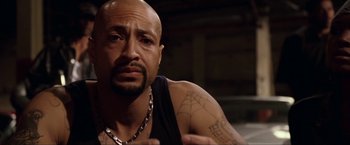 Movie still from “S.W.A.T.” (2003), directed by Clark Johnson – A bald man with a spider web tattoo on his arm; Close Up shot, High angle