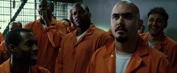 Movie still from “S.W.A.T.” (2003), directed by Clark Johnson – A group of men in orange jumpsuits standing in a room; Medium shot, Low angle