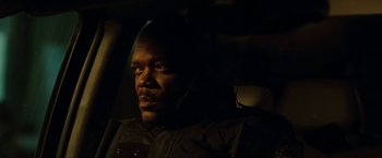 Movie still from “S.W.A.T.” (2003), directed by Clark Johnson – A man sitting in the back seat of a car; Close Up shot, Over the shoulder angle