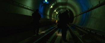 Movie still from “S.W.A.T.” (2003), directed by Clark Johnson – Two people are walking down the stairs in a subway tunnel; Wide shot, Low angle
