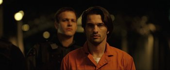 Movie still from “S.W.A.T.” (2003), directed by Clark Johnson – A man in an orange jacket standing next to another man in an orange jacket; Close Up shot, Low angle