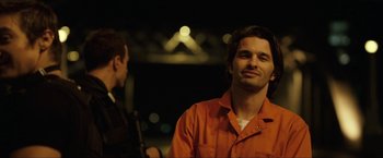 Movie still from “S.W.A.T.” (2003), directed by Clark Johnson – A man in an orange shirt is looking at the camera; Close Up shot, Over the shoulder angle