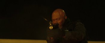 Movie still from “S.W.A.T.” (2003), directed by Clark Johnson – A man holding a gun in his hands; Medium shot, Low angle