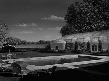 Movie still from “Sabrina” (1954), directed by Billy Wilder – An outdoor pool with a deck chair and umbrella in the foreground; Extreme Wide shot, High angle