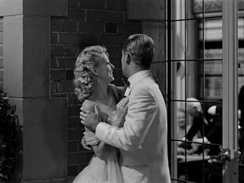 Movie still from “Sabrina” (1954), directed by Billy Wilder – A man and a woman dancing in front of a brick wall; Medium shot, Over the shoulder angle