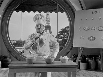 Movie still from “Sabrina” (1954), directed by Billy Wilder – A man wearing a chef's hat standing in front of two bowls of food; Medium shot, Low angle