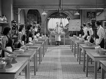 Movie still from “Sabrina” (1954), directed by Billy Wilder – A group of people sitting at tables in a room; Wide shot, High angle
