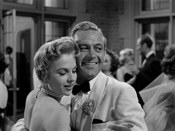 Movie still from “Sabrina” (1954), directed by Billy Wilder – A man and a woman posing for a picture; Medium shot, Low angle