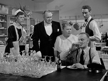 Movie still from “Sabrina” (1954), directed by Billy Wilder – A black and white photo of a group of people drinking wine; Medium shot, Over the shoulder angle