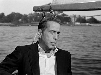 Movie still from “Sabrina” (1954), directed by Billy Wilder – Black and white photograph of a man on a boat; Close Up shot, Low angle