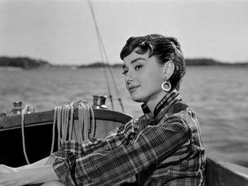 Movie still from “Sabrina” (1954), directed by Billy Wilder – A black - and - white photo of a woman sitting on a sailboat; Medium shot, Low angle