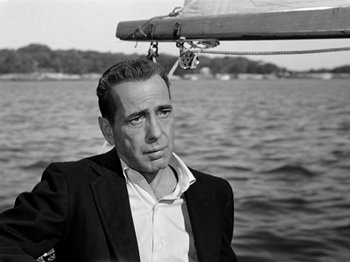Movie still from “Sabrina” (1954), directed by Billy Wilder – Black and white photograph of a man on a boat; Close Up shot, Low angle