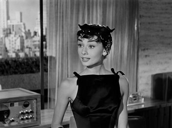 Movie still from “Sabrina” (1954), directed by Billy Wilder – A black and white photo of a woman in a black dress; Medium shot, Over the shoulder angle
