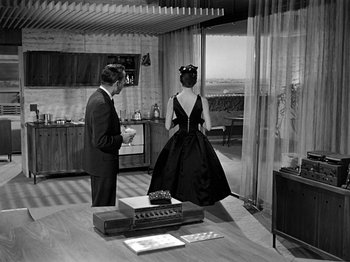 Movie still from “Sabrina” (1954), directed by Billy Wilder – A man and a woman standing in front of each other; Wide shot, High angle