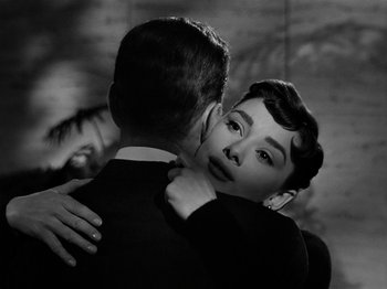 Movie still from “Sabrina” (1954), directed by Billy Wilder – A man and a woman embracing each other; Close Up shot, Over the shoulder angle