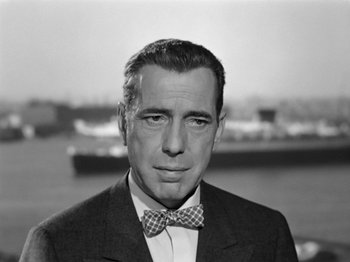 Movie still from “Sabrina” (1954), directed by Billy Wilder – Black and white photograph of a man wearing a bow tie; Close Up shot, Low angle