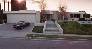 Movie still from “Safe” (1995), directed by Todd Haynes – A car is parked in front of a house with steps; Extreme Wide shot, High angle