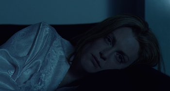 Movie still from “Safe” (1995), directed by Todd Haynes – A woman laying in a bed with her head on the ground; Close Up shot, High angle