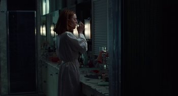 Movie still from “Safe” (1995), directed by Todd Haynes – A woman in a robe is drinking a glass of wine; Medium shot, Low angle