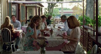 Movie still from “Safe” (1995), directed by Todd Haynes – A group of people sitting at a table with plates of food on it; Wide shot, Over the shoulder angle