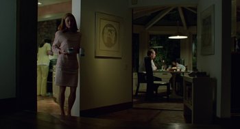 Movie still from “Safe” (1995), directed by Todd Haynes – A woman standing in a living room next to a table; Wide shot, Low angle
