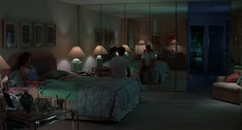 Movie still from “Safe” (1995), directed by Todd Haynes – Two people sitting on a bed in a bedroom; Wide shot, High angle