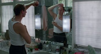 Movie still from “Safe” (1995), directed by Todd Haynes – A man in a white shirt is in the mirror; Medium shot, Over the shoulder angle