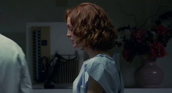 Movie still from “Safe” (1995), directed by Todd Haynes – A woman with red curly hair wearing a blue shirt; Medium shot, Over the shoulder angle
