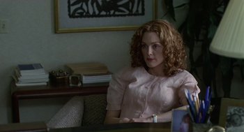 Movie still from “Safe” (1995), directed by Todd Haynes – A woman sitting at a table in a living room; Medium shot, Over the shoulder angle