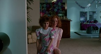 Movie still from “Safe” (1995), directed by Todd Haynes – Two young girls posing for a picture in a living room; Medium shot, High angle