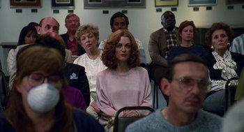 Movie still from “Safe” (1995), directed by Todd Haynes – A group of people sitting in front of a crowd; Medium shot, Over the shoulder angle