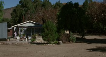 Movie still from “Safe” (1995), directed by Todd Haynes – A house sitting in the middle of a dirt field; Extreme Wide shot, High angle