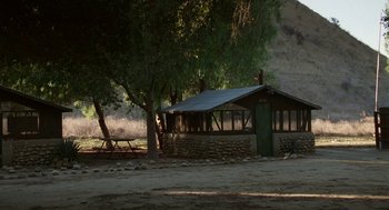 Movie still from “Safe” (1995), directed by Todd Haynes – A building that is next to some trees; Extreme Wide shot, High angle
