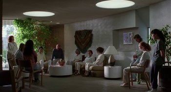 Movie still from “Safe” (1995), directed by Todd Haynes – A group of people sitting around a room; Wide shot, High angle