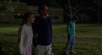 Movie still from “Safe” (1995), directed by Todd Haynes – A man and a woman standing next to each other in a field; Medium shot, Over the shoulder angle